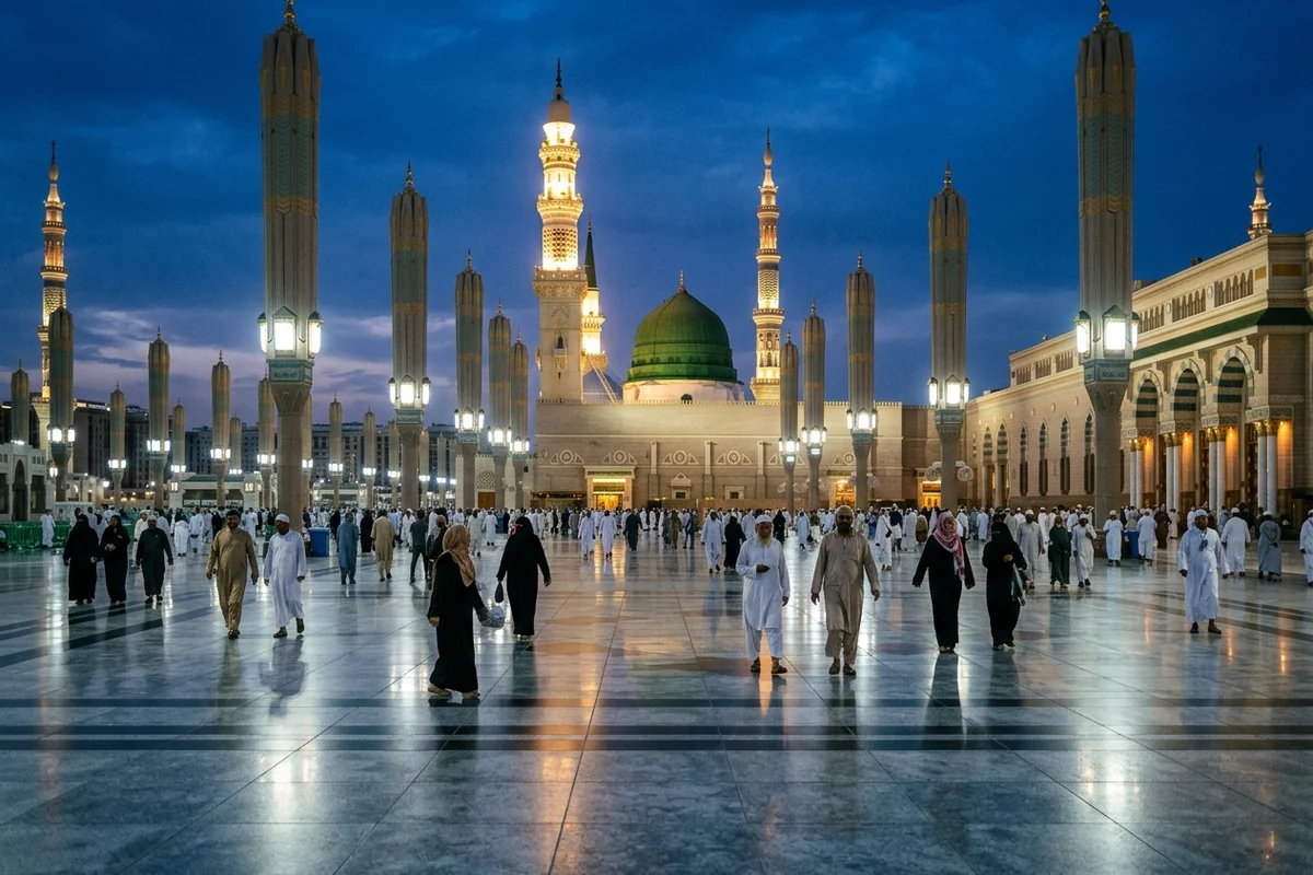 The Green Dome and minarets of Masjid an-Nabawi at dusk, with worshippers crossing the wet courtyard