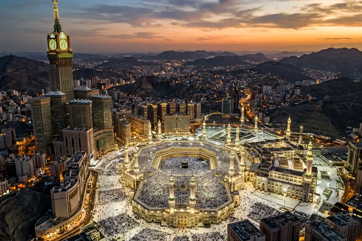 Masjid al-Haram and the Kaaba lit at dusk, seen from above with the Makkah Clock Tower beside them