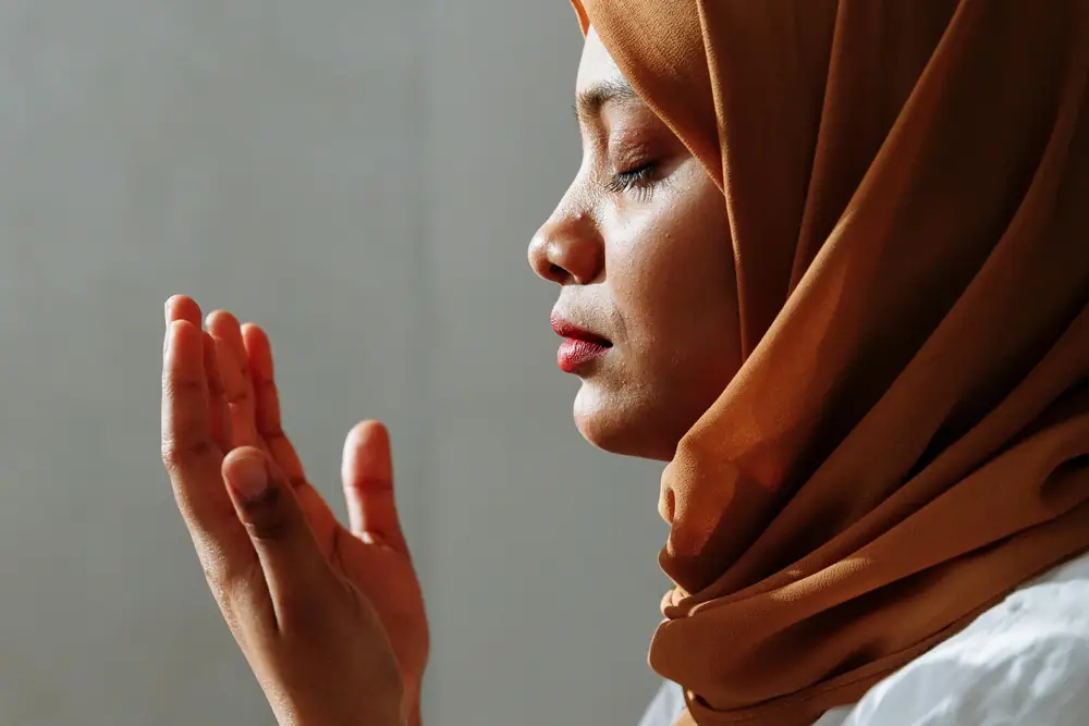 A woman raising her hands in prayer