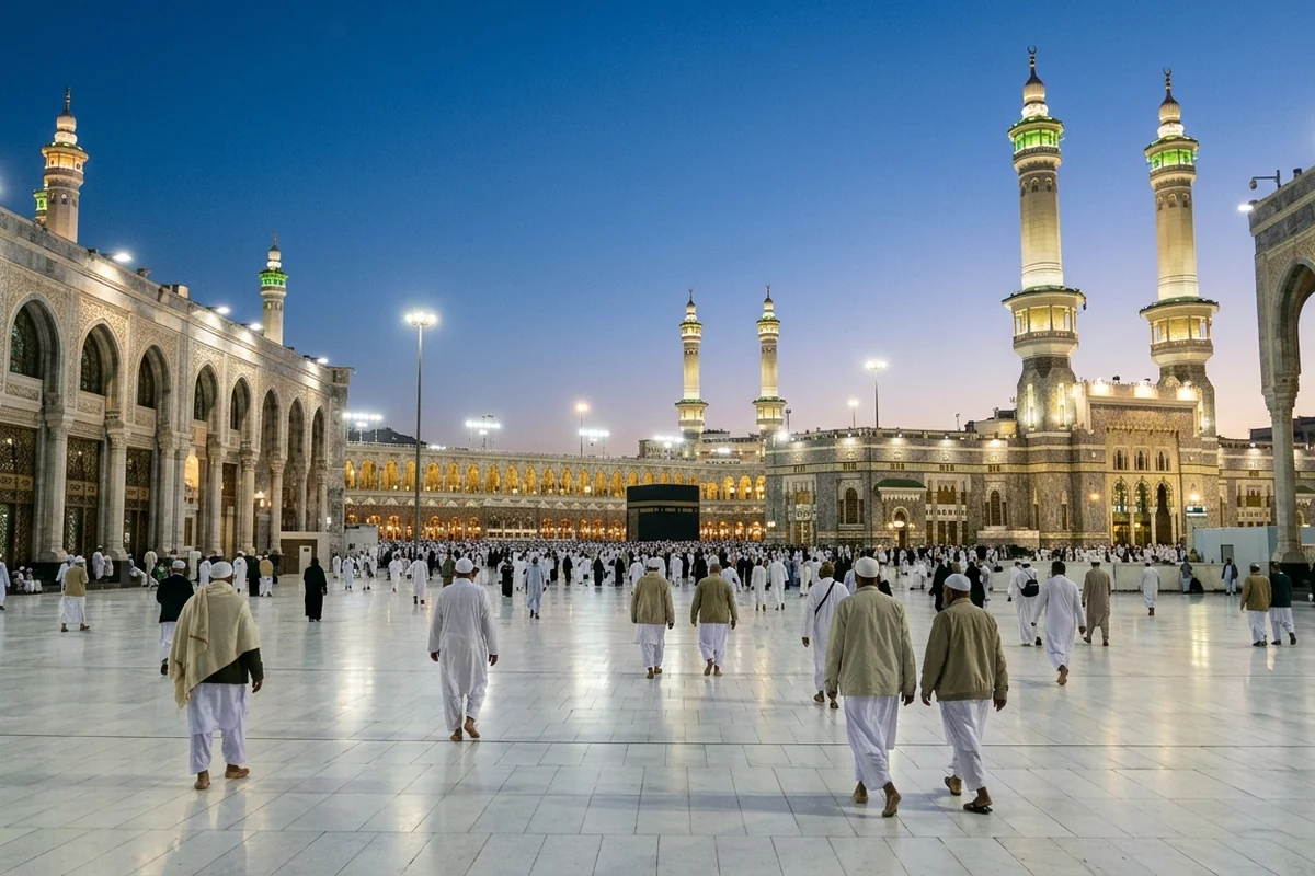 Pilgrims crossing a marble courtyard towards lit minarets at dusk