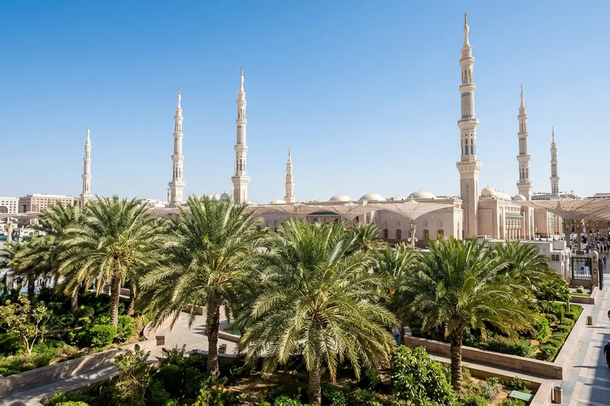 Minarets rising above a garden of palm trees under a clear blue sky