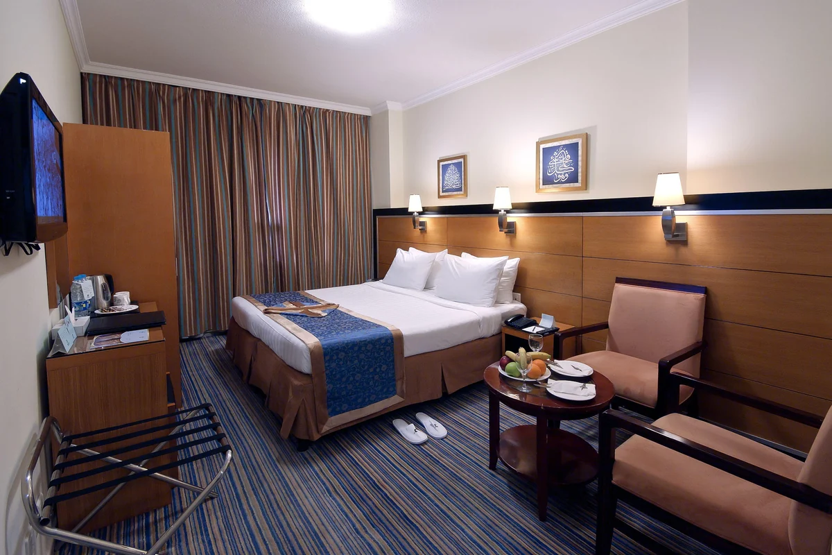 Double room with armchairs and TV at Durrat Al Eiman