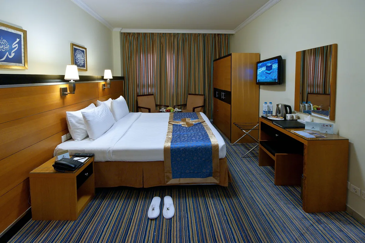 Deluxe room with large bed and desk at Durrat Al Eiman