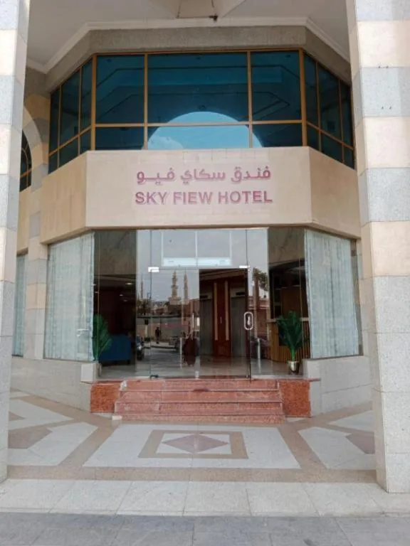 The glass entrance of Sky View Hotel in Madinah, with the hotel's sign above the doors